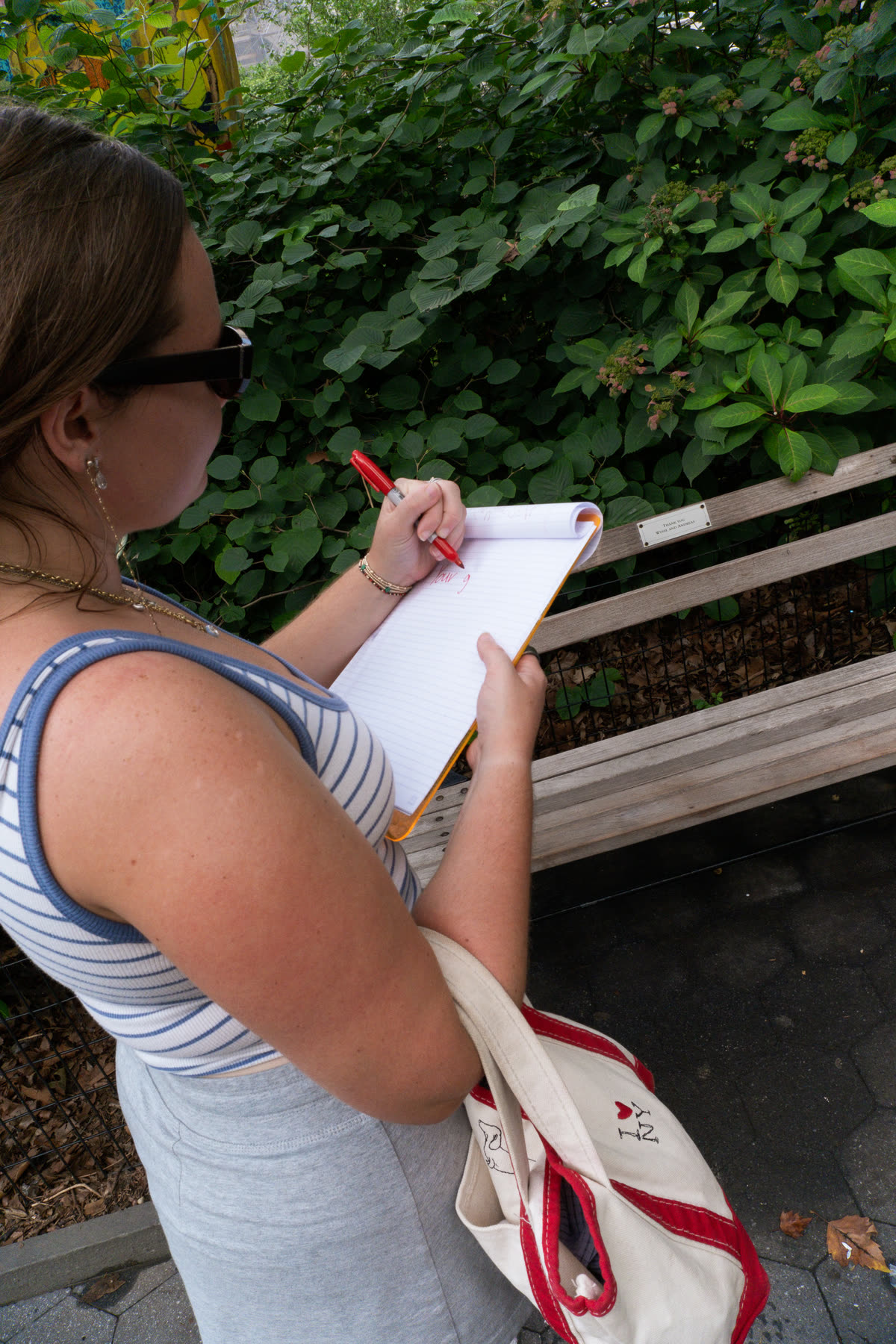 Third participant writing the next instruction at a park bench